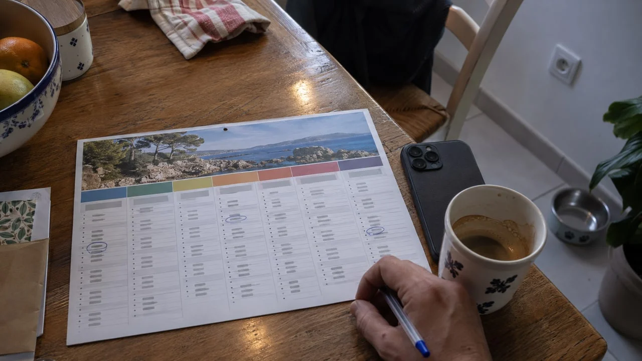 Calendrier mural annoté à la main sur une table de cuisine, évoquant les dates repères du suivi après une greffe