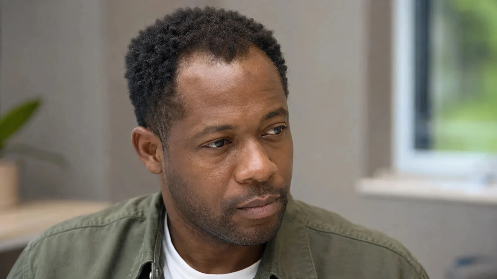 Portrait d'un homme aux cheveux crépus courts, avec un léger recul naturel des tempes