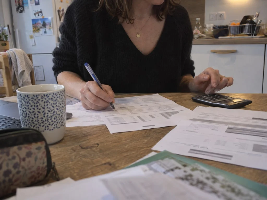 Calcul du reste à charge mensuel sur un coin de table : la participation de l'assuré s'applique au prix public du médicament, et ce qui reste dépend ensuite du contrat de complémentaire santé